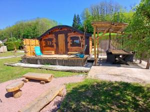 a log cabin with a picnic table and a grill at Les cabanes féeriques d'Amoncourt in Amoncourt