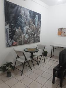a table and chairs in a room with a painting on the wall at Frente aeropuerto de Isla Verde in San Juan