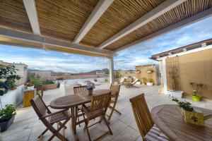 a patio with a table and chairs on a balcony at Rooms and Rooftop Terrace Olbia Center in Olbia