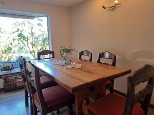 a dining room table with chairs and a large window at 2 personas, desayuno, gran ubicación in Osorno