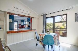 a dining room with a table and chairs and a window at Spearhead on Lake Accommodation-5A in Marina da Gama