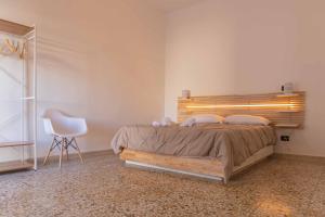 a bedroom with a bed with a chair and a window at Casa Caminari in Grottaglie