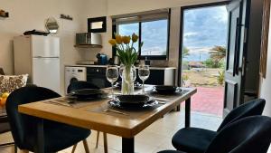 a kitchen with a table with wine glasses and flowers at Jacuzzi & Sunset by the Sea in Nahariyya +19 photos
