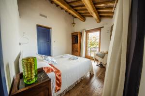 Schlafzimmer mit einem Bett, einem Tisch und einem Fenster in der Unterkunft Al Vicolo dei Pescatori in Anguillara Sabazia