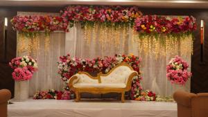 a stage with a couch and flowers on it at HOTEL KRRISH in Patna