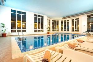 a swimming pool in a house with white chairs at Forest Retreat, Stream Resort, Pamporovo in Stoykite