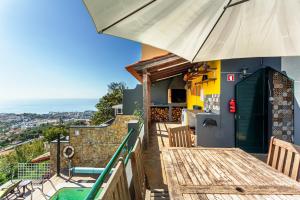einen Balkon eines Hauses mit einem Tisch und einem Sonnenschirm in der Unterkunft Casa Barcelos View in Funchal