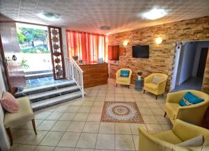 a living room with chairs and a tv and a staircase at Hotel George in Agios Kirykos