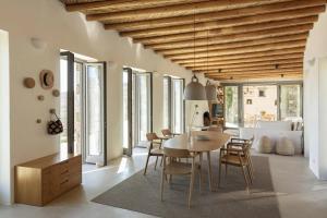 a dining room and living room with a table and chairs at Xerolithi Cycladic Awarded Villa in Serifos Chora
