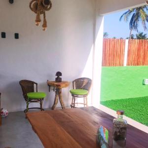 ein Raum mit Stühlen und einem Tisch und einem großen Fenster in der Unterkunft KaBeat House Icaraizinho in Amontada