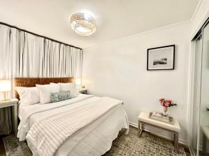 a white bedroom with a large bed and a window at Direct Luxury Oceanfront - On The Beach! Amazing Sunrises, 2 Pools & Bar! in Hilton Head Island +52 photos
