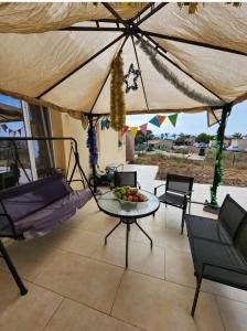 a patio with a table and chairs and an umbrella at Golden House גולדן האוז in Kidmat Tsvi