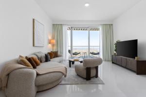 un soggiorno con un divano e una TV di Maison Privee - Coastal Living with Uninterrupted Sea & Palm Views a Dubai