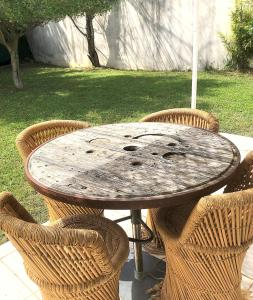 a wooden table with chairs and an umbrella at Le Clos St Roch- Family home in Montpellier! in Montpellier