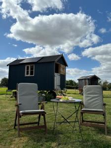 two chairs and a table in front of a tiny house at Marsh View in Haddiscoe