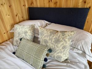 a bed with white sheets and pillows on it at Marsh View in Haddiscoe