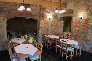 a restaurant with tables and chairs and a brick wall at Penzion Ve Skale in Loket