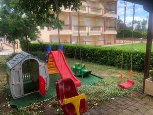 a playground with swings in a yard next to a building at Τηλεμαχος Apartments in Loutra Edipsou