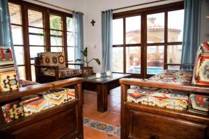 a living room with chairs and a table and windows at Casa Xcaanda, oceanfront with private pool in Puerto Ángel