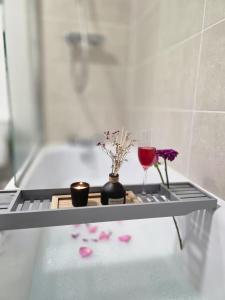 Una bandeja con una copa de vino y flores en un baño. en Oakham stay, en Oakham