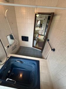 a blue tub in a bathroom with a mirror at Chiba Homestay by Lek บ้านพักใกล้นาริตะโตเกียว in Yotsukaidō +27 photos
