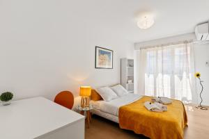a white bedroom with a bed and a window at Suite de Dijon FSHH in Nice