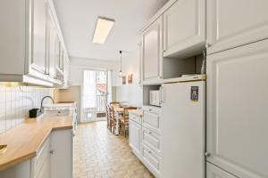 a kitchen with white cabinets and a white refrigerator at Suite de Dijon FSHH in Nice