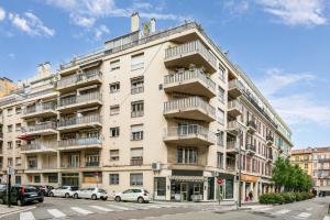 a large white building with cars parked in front of it at Suite de Dijon FSHH in Nice