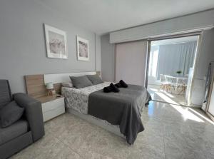 ein Schlafzimmer mit einem Bett und einer Couch und einem Fenster in der Unterkunft Torre principado 10 in Benidorm