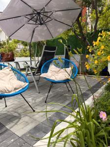 two chairs and an umbrella on a patio at Villa Gjoka in Velipojë