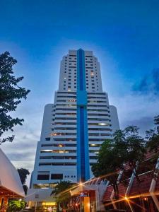 パトンビーチにあるPatong Towerの夜の青と白の高い建物
