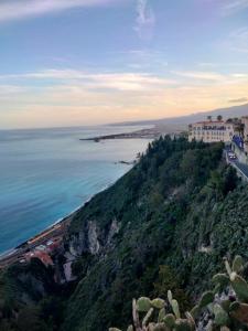 a building on top of a hill next to the ocean at Etna view Villa Letizia a Taormina in Taormina