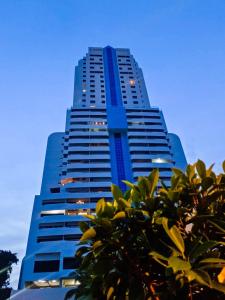 パトンビーチにあるPatong Towerの目の前に木々が立ち並ぶ高い青い建物