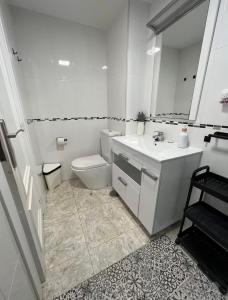 ein weißes Badezimmer mit Toilette und Waschbecken in der Unterkunft Torre principado 10 in Benidorm + 9 Fotos