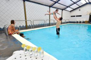 a man jumping into a swimming pool at Hotel Montecarlo in Ibarra