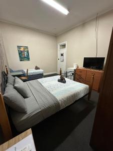 卡尔古利The Piccadilly Hotel的一间卧室，配有一张床、一张书桌和一台电视