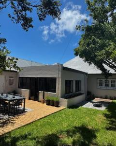 een huis met een patio en een tafel op een terras bij Stunning Home in Hermanus Town Centre in Hermanus