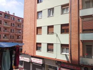 a tall brick building with windows on the side of it at Habitación in Bilbao