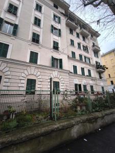 a large white building with a fence in front of it at Casa Giorgia with Parking Space in Genova