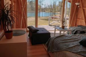 a room with a bed and a chair and a patio at Aimasas Kempings in Lielie Unguri