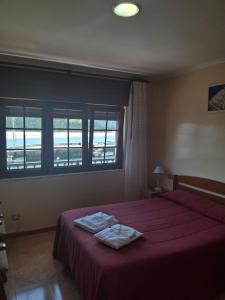 Un pat sau paturi într-o cameră la Hostal La Marina