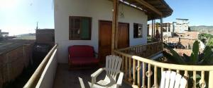 einen Balkon eines Hauses mit einem roten Stuhl in der Unterkunft Casa de Heidi in Puerto López