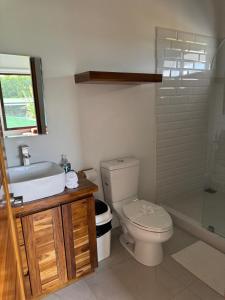 a bathroom with a toilet and a sink and a shower at Hotel Por Que No? in Uvita