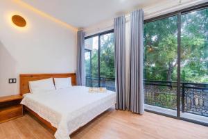 a bedroom with a bed and a large window at Như House Apartment Phú Quốc in Phu Quoc