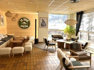 a restaurant with a waiting room with chairs and tables at Hôtel Club Le 1850 Risoul in Risoul