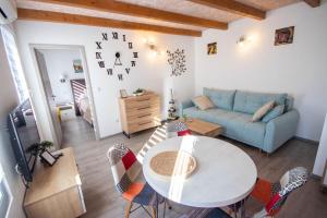 un soggiorno con un tavolo e un divano blu di A&D Apartments a Rovigno (Rovinj)