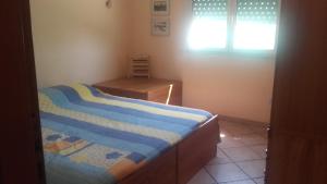 a bedroom with a bed and a desk and a window at Appartamento Arenella in Arenella