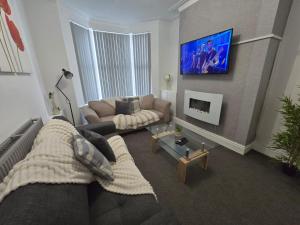 リバプールにあるRoom 3 Shared house in Kensingtonのソファとテレビのあるリビングルーム