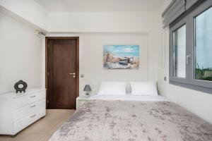 a white bedroom with a large bed and a window at Dias Luxury Villa in Koskinou +49 photos