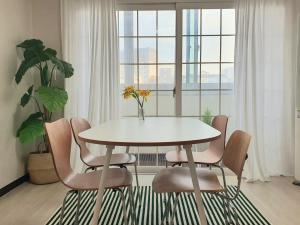 a white table and chairs in a room with a window at Soo Stay in Daegu